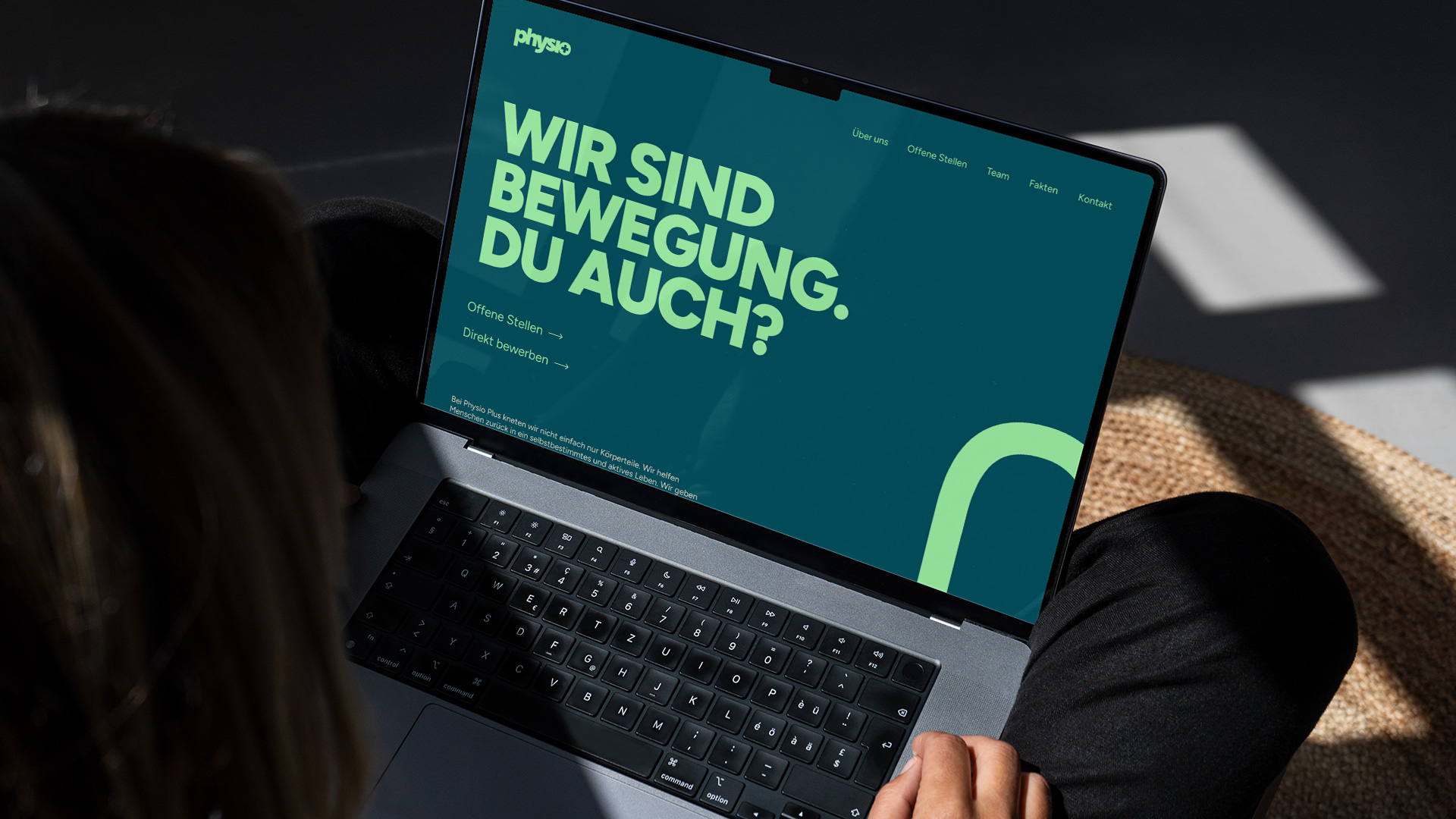 Laptop-Ansicht der Einstiegs-Sektion der Physio Plus Website von THIS IS JUJU mit dem Claim “Wir sind Bewegung. Du auch?” und einem Bewegung symbolisierenden Pfeil im neuen Corporate Identity Design.