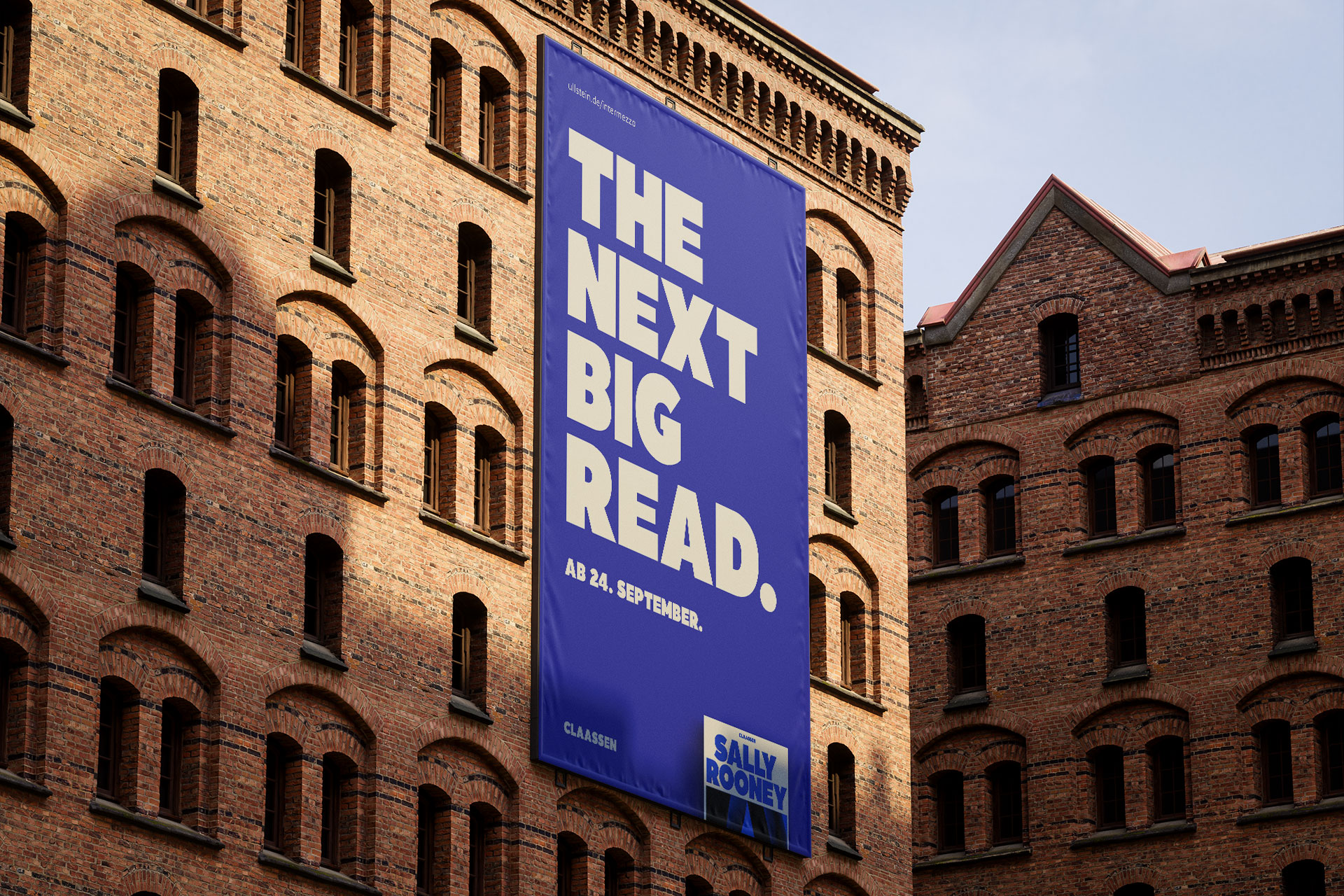 Großes Teaser-Plakat für „Intermezzo“ von Sally Rooney an einem Backstein-Gebäude, zeigt die Headline „The next big read“ und ein kleines Bild des Buchcovers, gestaltet von THIS IS JUJU.